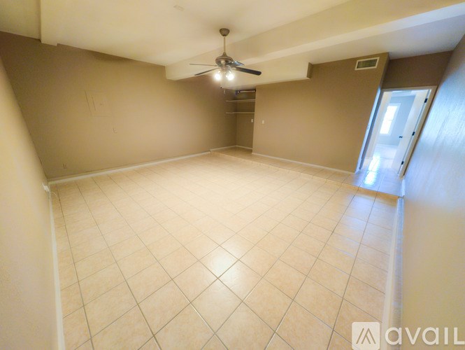 A room with a ceiling fan and tile flooring.