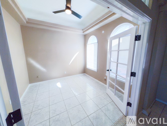 A room with a ceiling fan and tiled flooring.