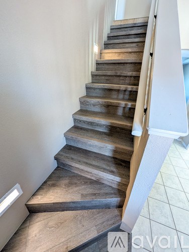 A set of stairs with wooden steps and a white handrail.