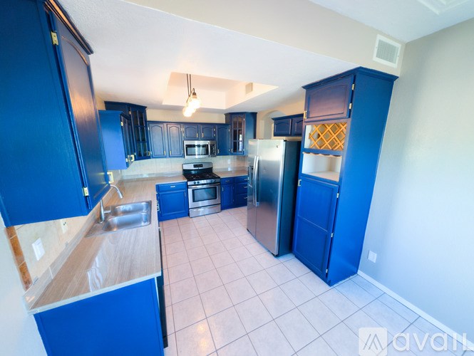 A kitchen with blue cabinets and appliances.