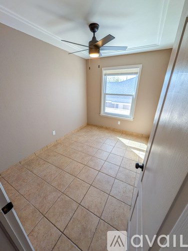 A room with a ceiling fan and a window.