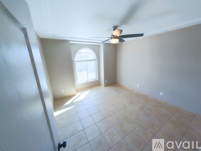A room with a ceiling fan and tiled floor.