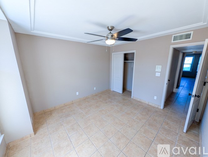 A room with a ceiling fan and tile flooring.