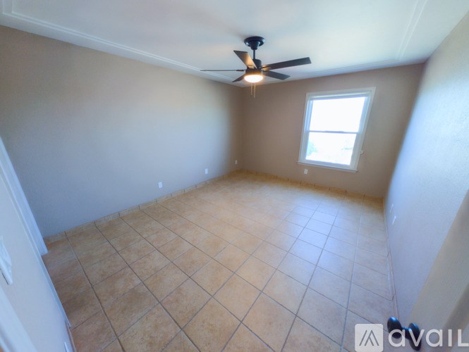 A room with a ceiling fan and tiled floor.