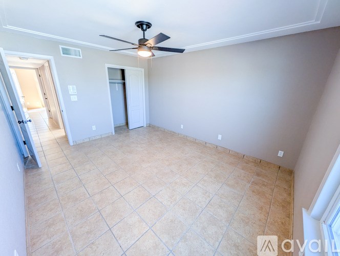 A living room with a ceiling fan and tiled floor.