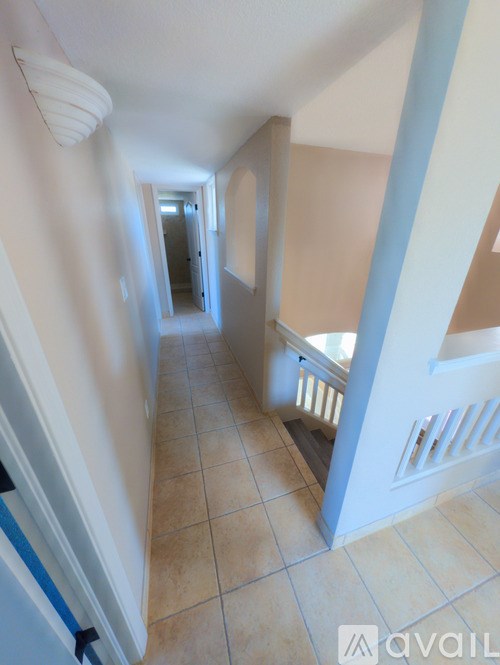 A hallway with a tiled floor and white walls.