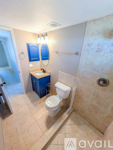 A bathroom with a toilet, sink, and mirror.