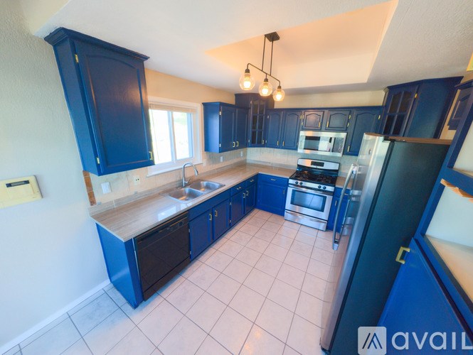 A kitchen with blue cabinets and a white counter.