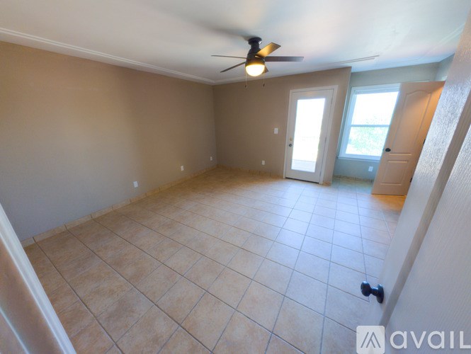 A room with a ceiling fan and tile flooring.
