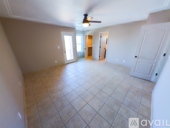 A spacious room with a ceiling fan and tile flooring.