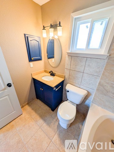 A bathroom with a toilet, sink, and mirror.