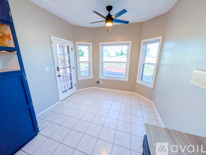 A room with a ceiling fan and tiled flooring.