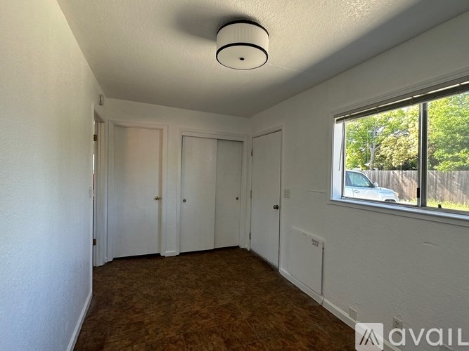 A room with white walls and a brown carpet is available for rent.