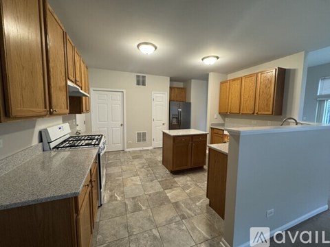 A kitchen with wooden cabinets and a granite countertop.