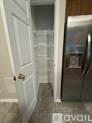 A kitchen with a white door and a stainless steel refrigerator.