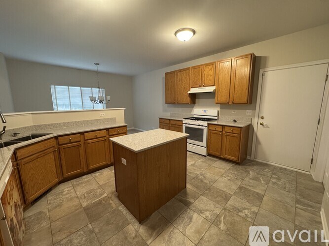 A kitchen with wooden cabinets and a tiled floor.