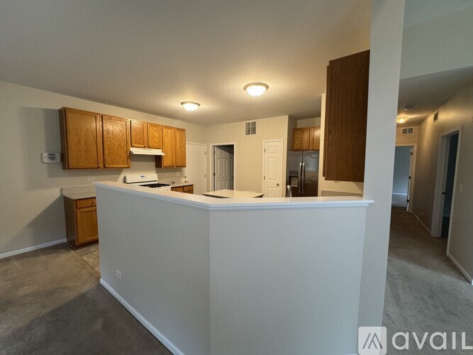 A kitchen with white countertops and wooden cabinets.