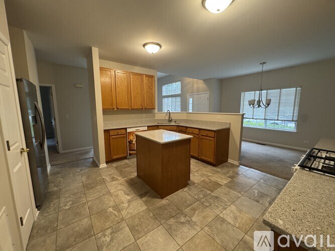 A kitchen with a central island and wooden cabinets.