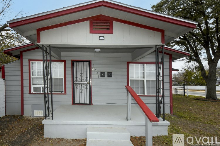 A small house with a red roof and white walls.