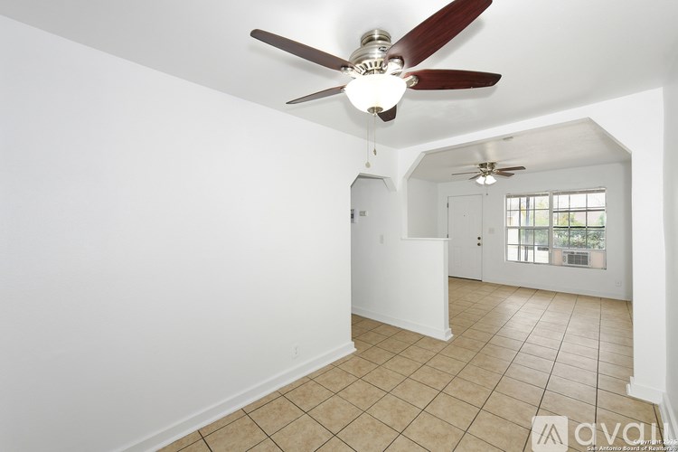 A room with a ceiling fan and tiled flooring.