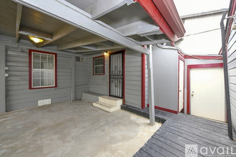 A patio area with a red awning and a white door.