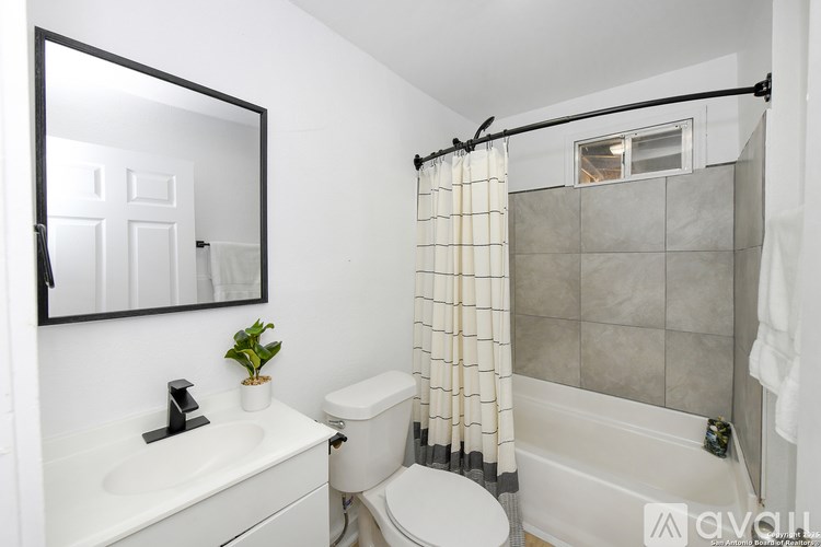 A bathroom with a white toilet, sink, and bathtub.