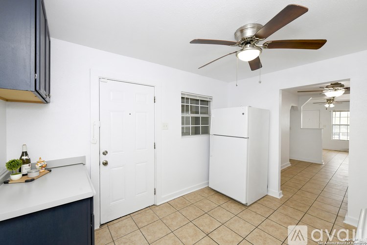 A room with a ceiling fan and a white door.