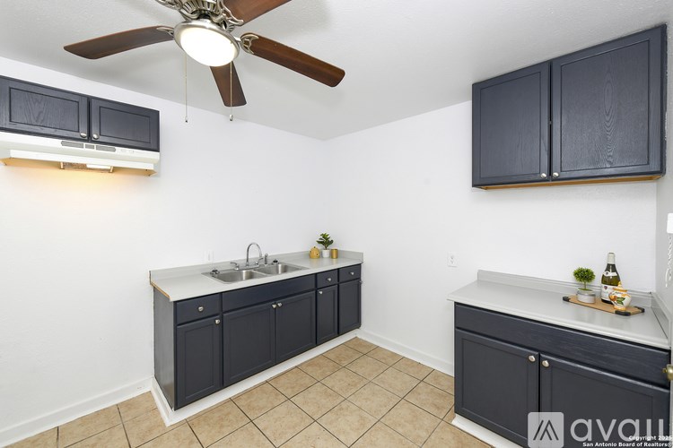 A kitchen with a fan and a sink.