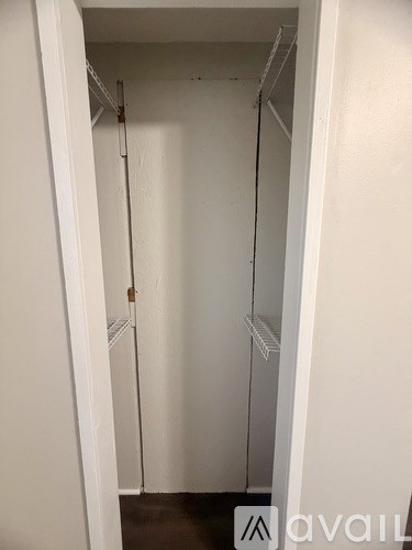 A white closet with a hanging rod and a door.