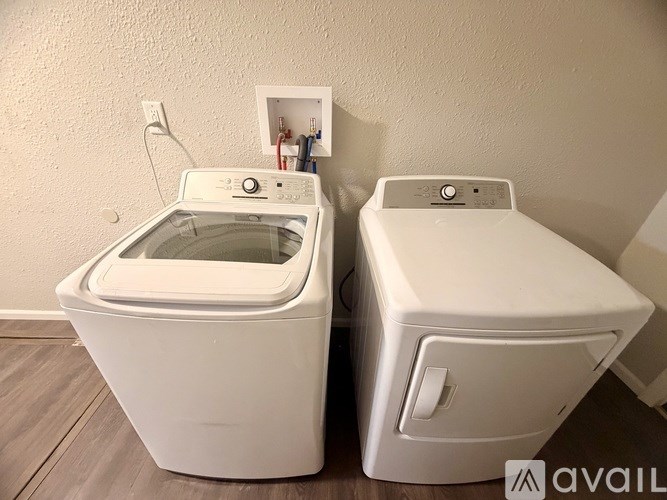 Two white washing machines are sitting next to each other.