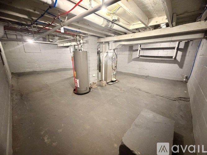 A concrete basement with a grey floor and white walls.