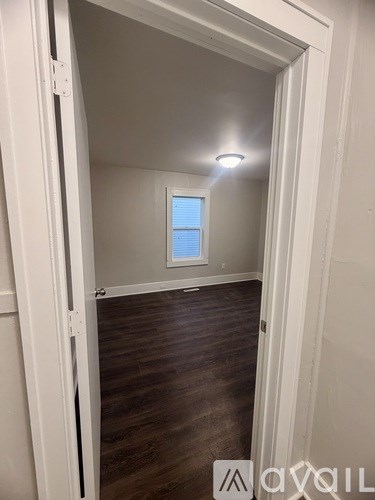 A room with a window and wooden flooring.