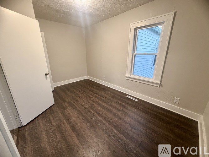 A room with a window and wooden flooring.