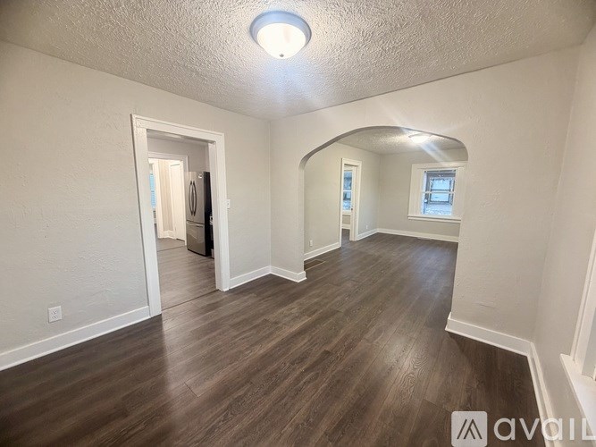 A room with wooden flooring and white walls.
