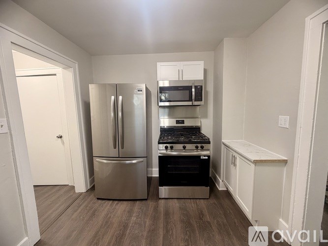 A kitchen with a stainless steel refrigerator, microwave, and stove.