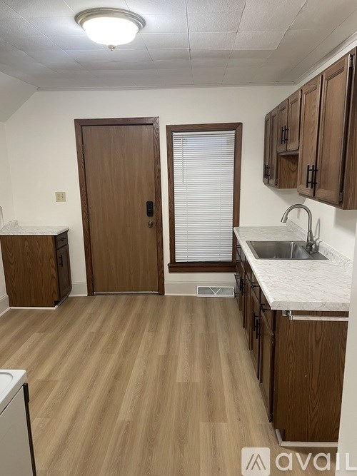 A kitchen with wooden floors and cabinets.