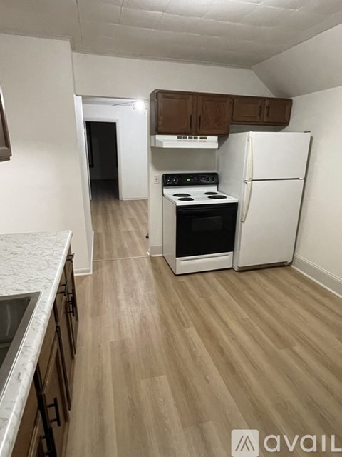 A kitchen with a white fridge, stove and oven.