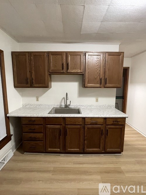A kitchen with wooden cabinets and a marble countertop.