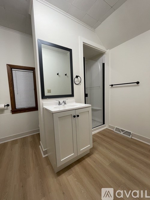 A bathroom with a white cabinet and a mirror.