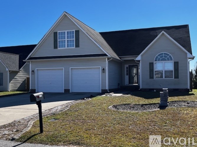 A two-story house with a garage and a driveway.