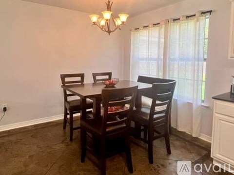 A dining room with a table and chairs.