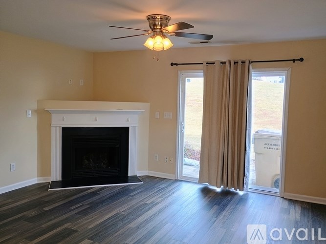 A living room with a fireplace and sliding glass doors.