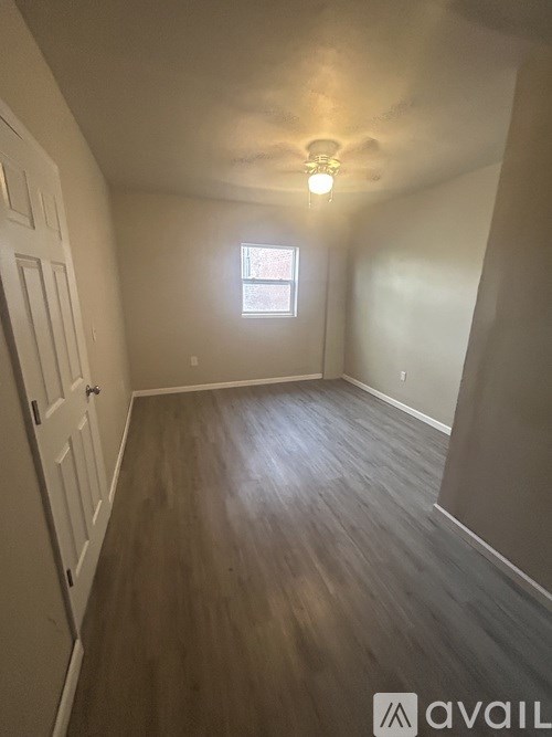 A room with wooden flooring and a window.