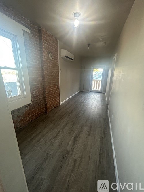 A room with a brick wall and wooden flooring.