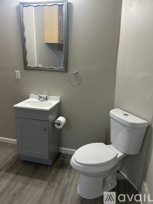A white toilet sits next to a sink in a bathroom.