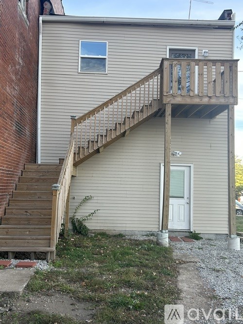 A house with a wooden staircase leading to a door.