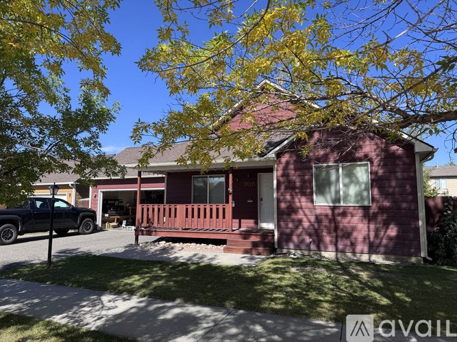 A house with a red brick exterior and a black truck parked in front.