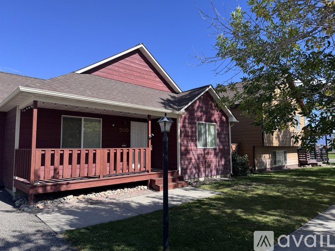 A red house with a porch and a sign that says "available".