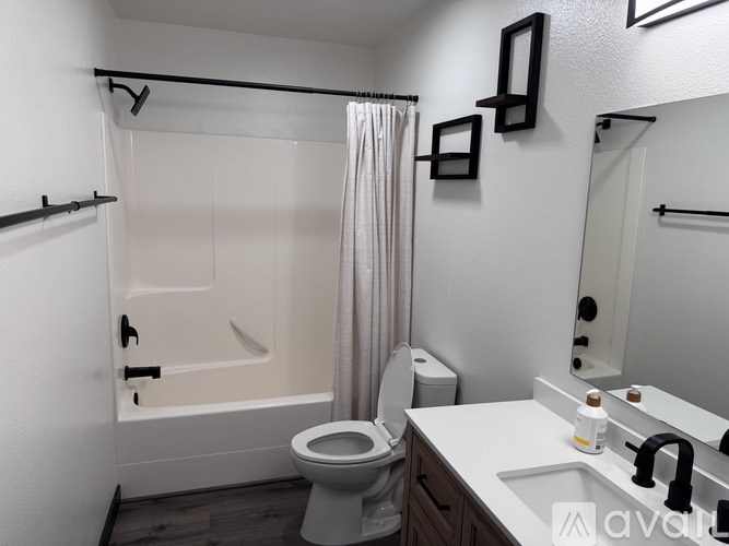 A white bathroom with a toilet, sink, and bathtub.