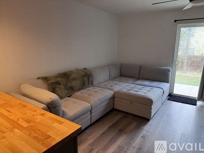 A living room with a grey couch and a wooden table.